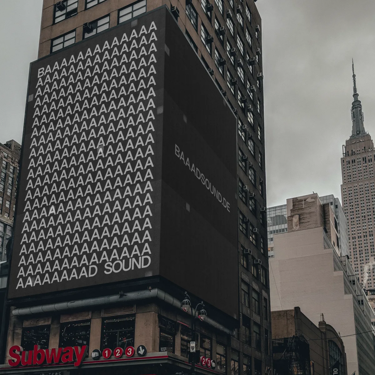 A New York street corner with the studio’s wordmark covering a tall building, the Empire State Building behind.
